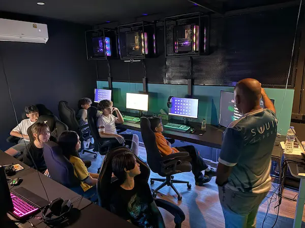 Coach teaching students in esports classroom